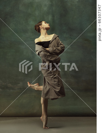 Young graceful tender ballerina on dark studio background Young graceful tender ballerina on dark studio background 66307347