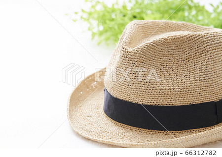 白いテーブル上に置かれた麦わら帽子の写真素材 白いテーブル上に置かれた麦わら帽子の写真素材