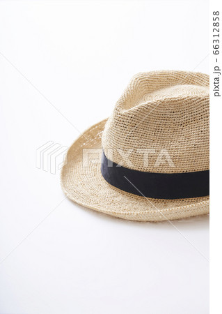 白いテーブル上に置かれた麦わら帽子 66312858