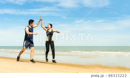 couple runners jump and touch hands And 66315222
