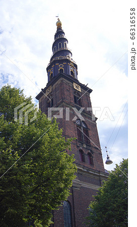 COPENHAGEN, DENMARK - JUL 06th, 2015: Our Saviour's Vor Frelsers Kirke - one of Denmark's most famous churches. Serpentine spire was inaugurated in 1752 - a popular pastime to climb 400 steps to top COPENHAGEN, DENMARK - JUL 06th, 2015: Our Saviour's Vor Frelsers Kirke - one of Denmark's most famous churches. Serpentine spire was inaugurated in 1752 - a popular pastime to climb 400 steps to top 66316558