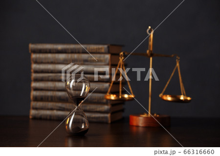 Judge's gavel, books, scales of justice and hourglass on wooden table. Law and justice concept Judge's gavel, books, scales of justice and hourglass on wooden table. Law and justice concept 66316660
