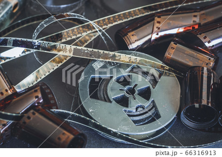 Old scratched 8 mm and 16mm film strips, bobbin, retro film and photo. Vintage background Old scratched 8 mm and 16mm film strips, bobbin, retro film and photo. Vintage background 66316913