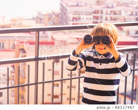 Blonde boy with binoculars exploring the city Blonde boy with binoculars exploring the city 66317487