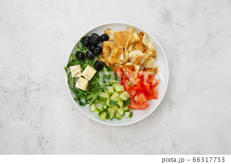 Healthy breakfast. Omelette with fresh mixed vegetables salad rocket, tomatoes, cucumber, olives, cheese. Top view. Healthy breakfast. Omelette with fresh mixed vegetables salad rocket, tomatoes, cucumber, olives, cheese. Top view. 66317753