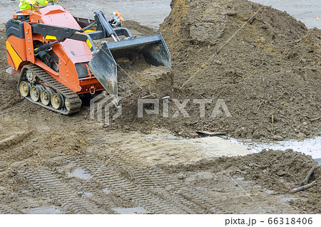 Excavator digging soil during pushes a ground 66318406