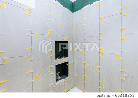 Bathroom construction laying floor and wall tile 66318855