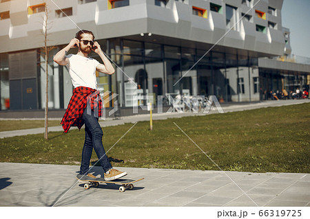 Stylish guy with skate in a summer city 66319725