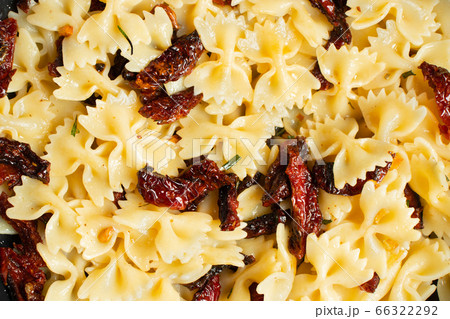 Pan-fried pasta with sun-dried tomatoes and garlic. Stages of cooking Italian cuisine, top view 66322292