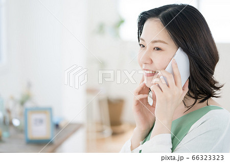 スマホで通話するミドル女性【リビング】 スマホで通話するミドル女性【リビング】 66323323