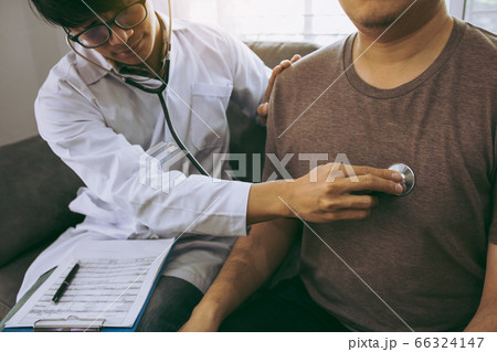 Asian doctor is using a stethoscope listen to the 66324147