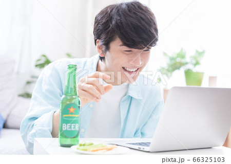 ノートパソコンでオンライン飲み会に参加する若い男性 ノートパソコンでオンライン飲み会に参加する若い男性 66325103