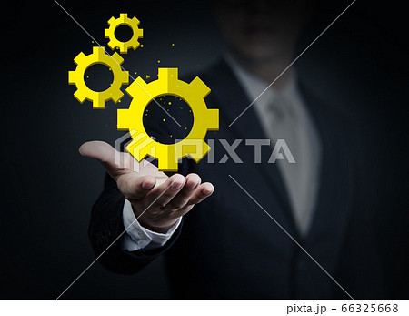 Close up of businessman holding gear mechanism in 66325668