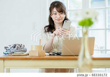 フリマアプリに洋服を出品している女性 66330172