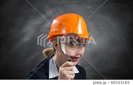 Building inspector looking through magnifier Building inspector looking through magnifier 66333165