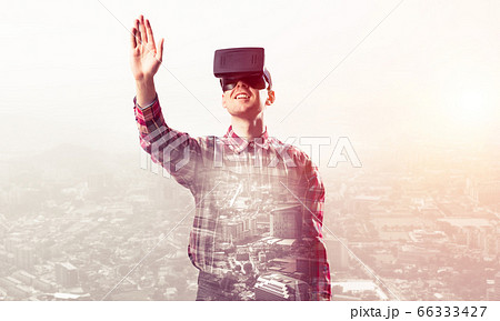 Guy wearing checked shirt and virtual mask stretching hand to touch something Guy wearing checked shirt and virtual mask stretching hand to touch something 66333427