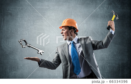 Businessman going to crash with hammer steel key Businessman going to crash with hammer steel key 66334396