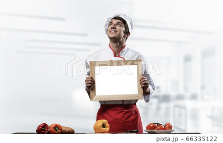 Young male chef standing near cooking table Young male chef standing near cooking table 66335122