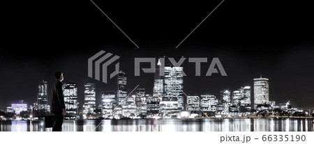 Businessman viewing night glowing city Businessman viewing night glowing city 66335190
