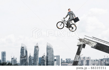 Man on bike jumping from broken bridge Man on bike jumping from broken bridge 66335551