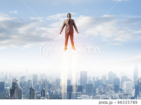 Businessman in suit and aviator hat flying in sky Businessman in suit and aviator hat flying in sky 66335789