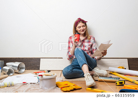 Beautiful girl sitting with paper blueprint Beautiful girl sitting with paper blueprint 66335959