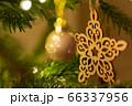 A wooden star shaped Christmas Tree Decoration hanging from a tree 66337956