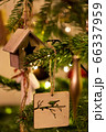 A wooden house shaped Christmas Tree Decoration hanging from a tree 66337959