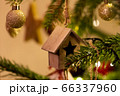 A wooden house shaped Christmas Tree Decoration hanging from a tree 66337960