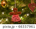 A fabric gingerbread man woman bear shaped Christmas Tree Decoration hanging from a tree 66337961