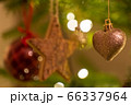 A glittery heart  shaped Christmas Tree Decoration hanging from a tree 66337964