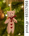 A white wooden bear shaped Christmas Tree Decoration hanging from a tree 66337968