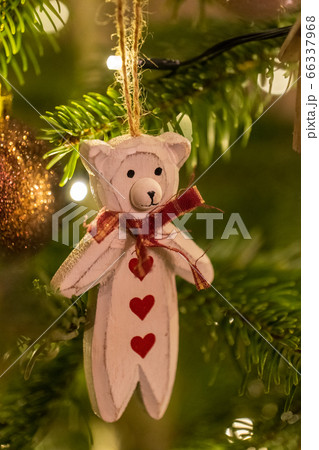 A white wooden bear shaped Christmas Tree Decoration hanging from a tree 66337968
