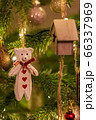 A white wooden bear shaped Christmas Tree Decoration hanging from a tree 66337969