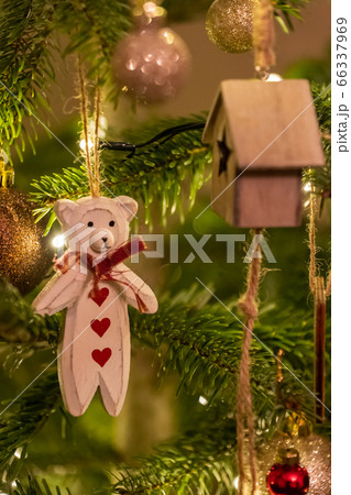 A white wooden bear shaped Christmas Tree Decoration hanging from a tree A white wooden bear shaped Christmas Tree Decoration hanging from a tree 66337969