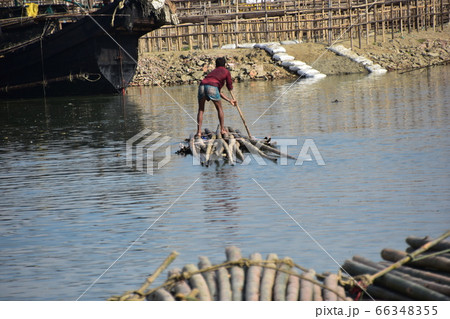 バングラデシュのコックスバザール　海岸沿いの村と停留中の船　筏に乗り竹を運ぶ男性 66348355