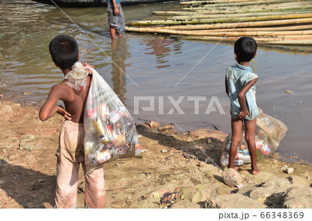バングラデシュのコックスバザール　生活の為に海岸でゴミを集める少年　海に浮かぶ沢山の竹 66348369
