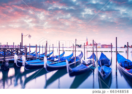 Row of gondolas parked on city pier 66348858