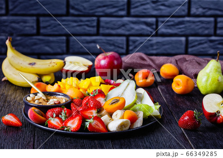 Fruit mix and peanut butter in front of black wall 66349285