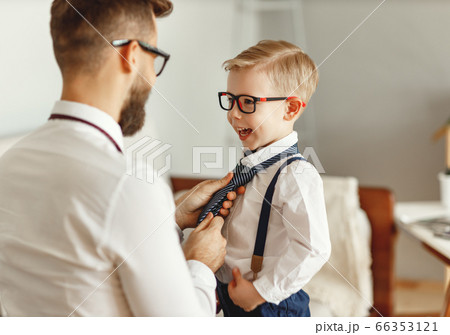 Father dressing son at home. 66353121