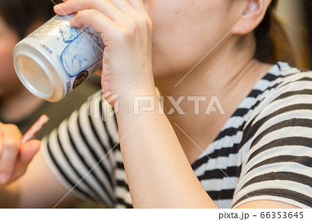 缶ジュースを飲む女性の口元の写真素材