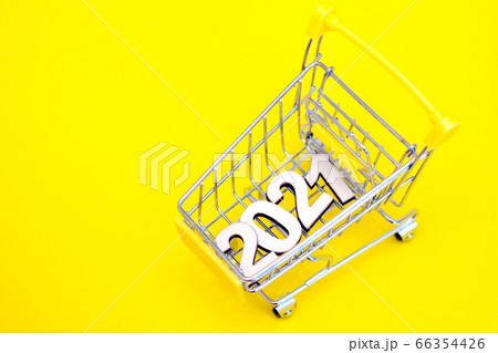 The numbers 2021 in a supermarket toy cart on a yellow background. 66354426