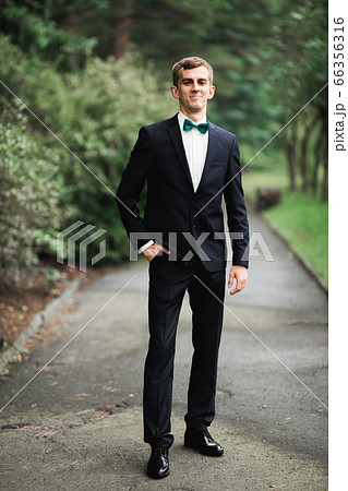 Headshot portrait of young man smiling isolated on outside outdoors background 66356316