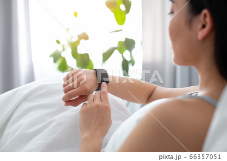 Female using tracker while staying in bed Female using tracker while staying in bed 66357051