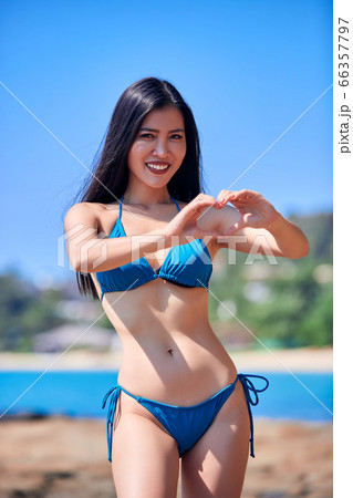 Asian girl in a blue bikini showing heart - love's Asian girl in a blue bikini showing heart - love's 66357797