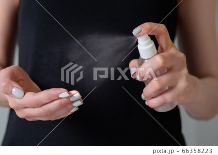 Woman spraying antiseptic on hands - close up - spray disinfection Woman spraying antiseptic on hands - close up - spray disinfection 66358223