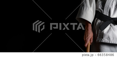 A person practicing aikido on a black background. 66358486