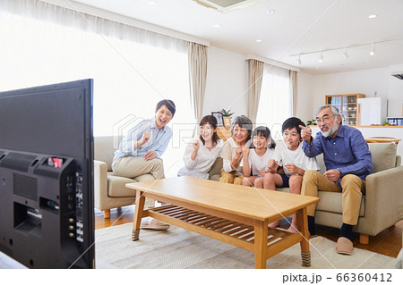 ソファーに座りテレビ観戦する3世代ファミリー　リビングダイニング 66360412