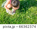 シロツメクサを集めて花束にする女の子 自然の遊びイメージ 66362374