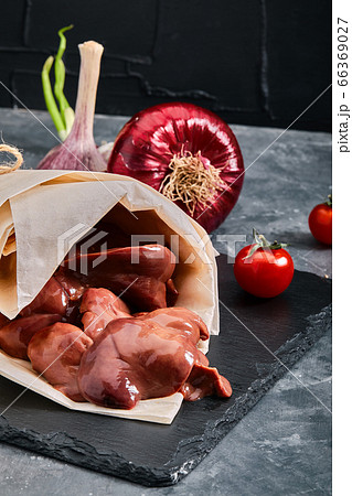 Raw chicken liver. Raw chicken fillet on a gray cement background. Copy space, eco packaging, grocery delivery. 66369027
